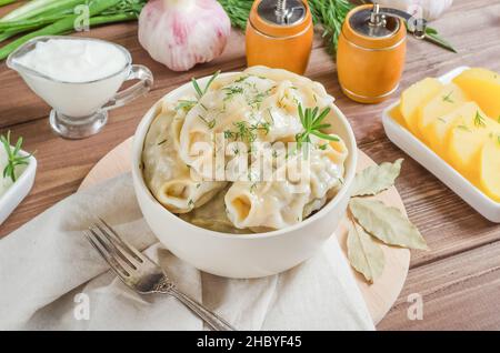 Knödel mit Fischfüllung in einer Schüssel auf dunklem Holzgrund Stockfoto
