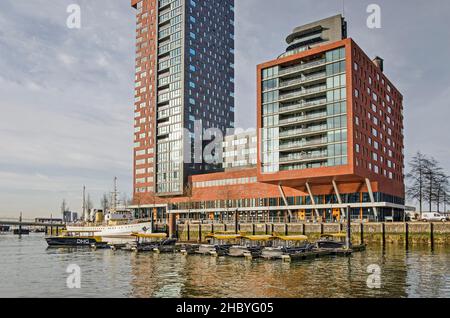 Rotterdam, Niederlande, 22. Dezember 2021: An einem sonnigen Tag im Hafen von Rijnhaven neben dem Wohnturm von Montevideo verankern Wassertaxis Stockfoto