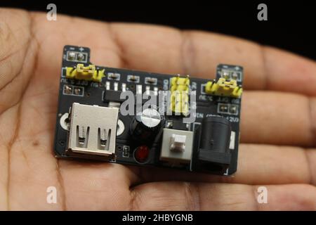 Stromversorgungsmodul für Breadboard mit USB- und dc-Pin-Steckplatz in der Hand Stockfoto