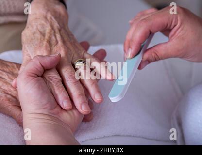 Nagelpflege für einen Senioren in einem Pflegeheim, Berlin, Deutschland Stockfoto