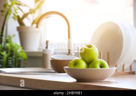 Schüssel mit grünen Äpfeln auf dem Tisch in der Küche, Nahaufnahme Stockfoto