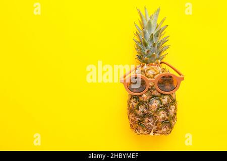 Frische Ananas in Sonnenbrillen auf gelbem Hintergrund Stockfoto