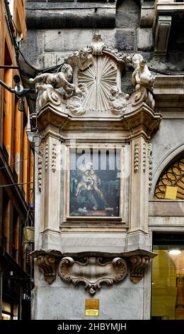 Nahaufnahme des Votivschreines „Jungfrau Maria mit dem Jesuskind und den Heiligen“ an einer Ecke der Piazza San Luca in der Altstadt von Genua, Ligurien, Italien Stockfoto