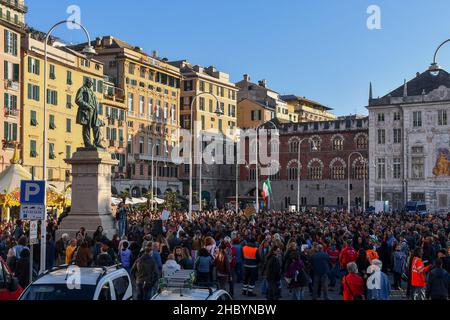 Genua, Ligurien, Italien - 10 23 2021: Menschenmenge bei einer Protestkundgebung ohne Green Pass auf der Piazza Caricamento mit dem Palazzo San Giorgio im Hintergrund Stockfoto