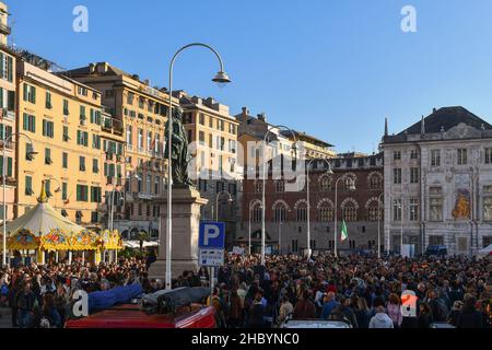 Genua, Ligurien, Italien - 10 23 2021: Menschenmenge bei einer Protestkundgebung ohne Green Pass auf der Piazza Caricamento mit dem Palazzo San Giorgio im Hintergrund Stockfoto