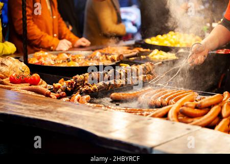 Krakau, Polen, gesunde traditionelle Street Food Stall, Gruppe anonymer Menschen, Stadtleben, Lebensstil, Rauch über Essen, Fleisch, Nahaufnahme des Tisches, Hände wi Stockfoto