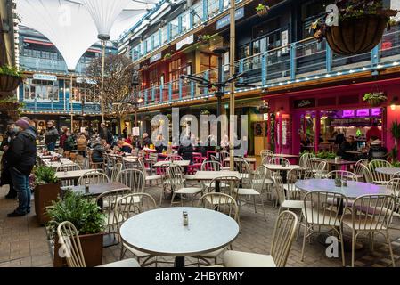 London, Großbritannien. 22. Dezember 2021. Ein paar Kunden, die im Kingly Court in der Carnaby Street speisen. Hospitality-Unternehmen sehen sich in der Zeit, in der sie normalerweise am meisten frequentierten Zeit des Jahres sind, mit reduzierten Einnahmen konfrontiert, da die Kunden aufgrund der Omicron-Variante Buchungen stornieren. Rishi Sunak, Schatzkanzler, hat Pläne für einen £1bn-Fonds angekündigt, um Unternehmen zu helfen, die von dem Anstieg der Covid-Fälle betroffen sind, einschließlich des Freizeit- und Gastgewerbes. Kredit: Stephen Chung / Alamy Live Nachrichten Stockfoto
