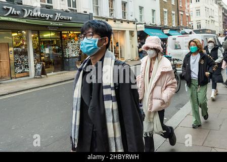 London, Großbritannien. 22. Dezember 2021. Menschen mit Gesichtsmasken in einer ruhigen Old Compton Street, Soho. Hospitality-Unternehmen sehen sich in der Zeit, in der sie normalerweise am meisten frequentierten Zeit des Jahres sind, mit reduzierten Einnahmen konfrontiert, da die Kunden aufgrund der Omicron-Variante Buchungen stornieren. Rishi Sunak, Schatzkanzler, hat Pläne für einen £1bn-Fonds angekündigt, um Unternehmen zu helfen, die von dem Anstieg der Covid-Fälle betroffen sind, einschließlich des Freizeit- und Gastgewerbes. Kredit: Stephen Chung / Alamy Live Nachrichten Stockfoto