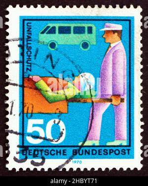 DEUTSCHLAND - UM 1970: Ein in Deutschland gedruckter Stempel zeigt den Keilträger, Unfall und Krankenwagen, der verschiedene Freiwilligendienste ehrt, um 1970 Stockfoto