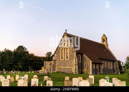 Die christliche Kirche der Heiligen Jungfrau Maria in Reculver in Kent. Viktorianisches Gebäude im neugotischen Stil. Flint Wände und rotes Ziegeldach. Stockfoto