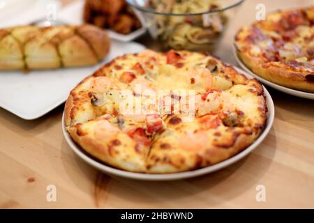Das italienische Essen namens Pizza und Spaghetti wurde auf dem Holztisch serviert. Stockfoto