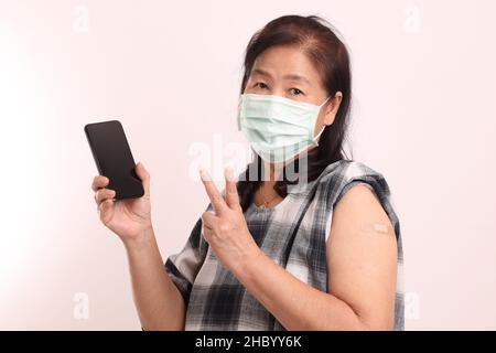 Der ältere asiatische Mann Porträt mit Kunststoff-Verband in den weißen Hintergrund. Stockfoto