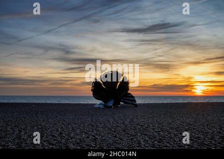 Sonnenaufgang über Maggi Hambling's Skulptur des Scallop am Kiesstrand in Aldeburgh, Großbritannien Stockfoto