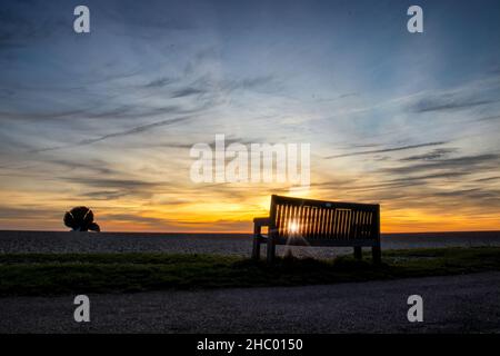 Sonnenaufgang über Maggi Hambling's Skulptur des Scallop am Kiesstrand in Aldeburgh, Großbritannien Stockfoto