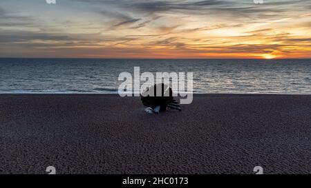 Sonnenaufgang über Maggi Hambling's Skulptur des Scallop am Kiesstrand in Aldeburgh, Großbritannien Stockfoto