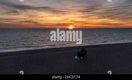 Sonnenaufgang über Maggi Hambling's Skulptur des Scallop am Kiesstrand in Aldeburgh, Großbritannien Stockfoto