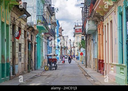 Bunte Gebäude und Bikitaxi / Fahrrad-Taxi in verfallenen Straße im kolonialen Stadtzentrum von Havanna, La Habana auf der Insel Kuba, Karibik Stockfoto