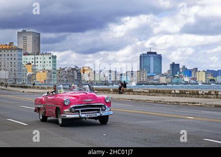 Pink Taxi, Vintage Chevrolet Bel Air 1953 Cabriolet auf der Malecón / Avenida de Maceo, Avenue und Ufermauer entlang der Stadt Havanna auf der Insel Kuba Stockfoto