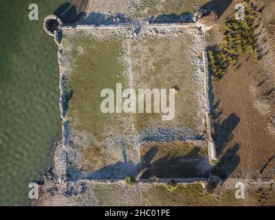 Drohne aus der Luft. Fortino di Mazzallakkar, zerstörte arabische Festung in Sambuca di Sicilia, Sizilien. Es liegt am Lago Arancio und wird gelegentlich von Wasser überflutet. Stockfoto