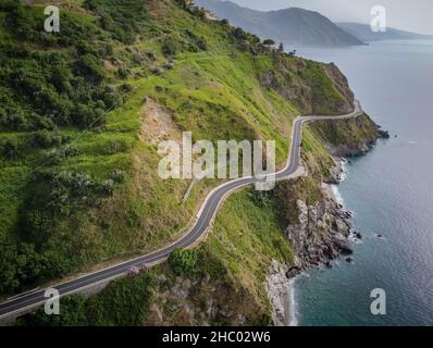Luftaufnahme der SS113, einer kurvenreichen Straße am Rande einer felsigen Klippe über dem tiefblauen Tyrrhenischen Meer zwischen Capo Skino und Capo Calava in Sizilien Stockfoto
