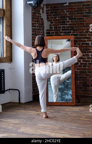 Junge Sportliche Frau steht Yoga-Pose im Loft Studio. Stockfoto