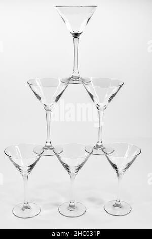 Leere martini-Cocktailgläser stehen auf weißem Hintergrund übereinander Stockfoto