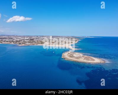 Luftdrohnenansicht der Insel und des Strandes von Isola delle Correnti. Leuchtturm umgeben von klarem türkisfarbenem Meerwasser in Portopalo di capo Passero, Sizilien Stockfoto