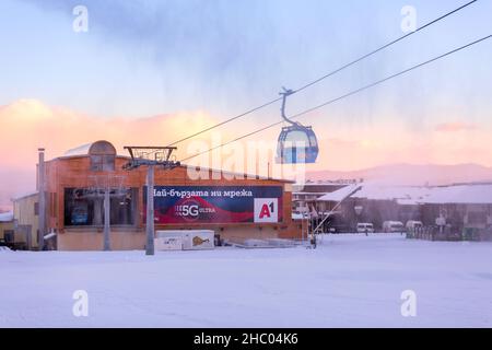 Bansko, Bulgarien - 21. Dezember 2021: Bulgarisches Winter-Skigebiet mit Skipiste, Lifthütten und Gondelstation Stockfoto