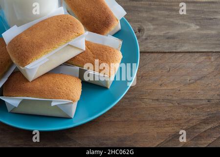 Mantecadas handgemachtes typisch spanisches Dessert. Cupcakes mit blauem Teller auf Holzhintergrund. Speicherplatz kopieren. Stockfoto