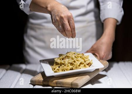 Studio-Foto von bestreuen Petersilienflocken auf einem Teller Bowtie Pasta. Stockfoto