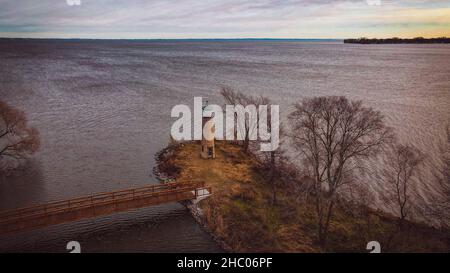 Der alte Leuchtturm auf der Insel blickt auf den See Stockfoto