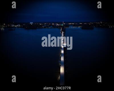 Luftaufnahme des Böllerweges. Eine einst verlassene Eisenbahnbrücke, die jetzt in einen Wanderweg über den See umgewandelt wurde. Leuchtende Farben bei Nacht. Neenah WI Stockfoto