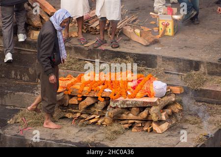 Ein Familienmitglied schaut vor der Einäscherungszeremonie auf den Leichnam des Verstorbenen. Pashupatinath, Kathmandu, Nepal. Stockfoto