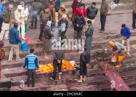 Trauernde räuchern im Rahmen der Hindu-Einäscherungszeremonie im Pashumpatinath, Kathmandu, Nepal. Stockfoto