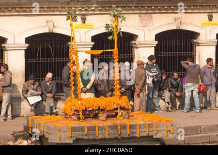 Ein mit Ringelblumen geschmückter Scheiterhaufen im Pashupatinath-Tempelkomplex in Kathmandu, Nepal. Stockfoto