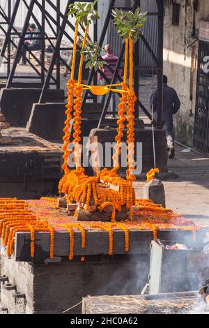 Ein mit Ringelblumen geschmückter Scheiterhaufen im Pashupatinath-Tempelkomplex in Kathmandu, Nepal. Stockfoto