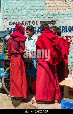 Junge buddhistische Mönche kaufen indisches puri-Brot bei einem Händler der Boudhanath Stupa in Kathmandu, Nepal. Stockfoto