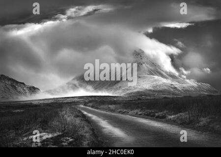 Der schneebedeckte Mount Errigal war von Sturmwolken umhüllt. Der Errigal-Gipfel im Westen von Donegal ist ein beliebter Ort für Touristen und Bergsteiger. Stockfoto