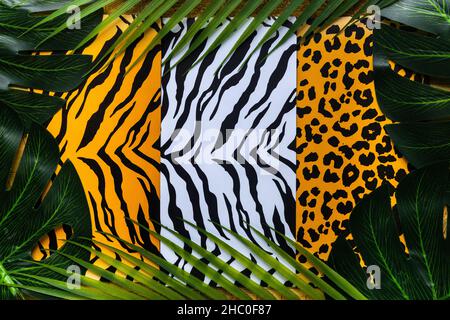 Kreatives Layout, Hintergrund verbunden mit Wildheit, Freiheit und Natur, Muster von Tiger, jaguar und Zebra Haut umgeben von Dschungel grün, Flat la Stockfoto
