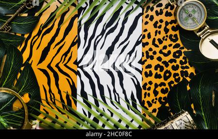 Kreatives Layout, Hintergrund verbunden mit Wildheit, Freiheit und Natur, Muster von Tiger-, jaguar- und Zebra-Hautfarben, umgeben von Dschungelgrün c Stockfoto