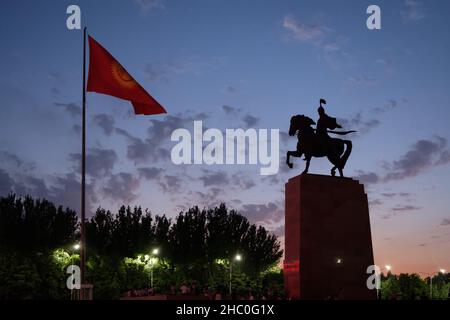 Manas Reiterstatue und kirgisische Nationalflagge bei Nacht. Bischkek, Kirgisistan Stockfoto