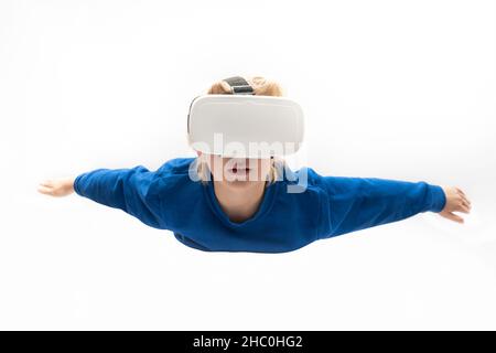 Junge in Virtual-Reality-Brille fliegt auf weißem Hintergrund. Virtual-Reality-Spiele, VR-Brillen. Stockfoto