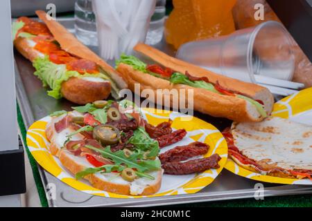 Sandwich mit Rucola, Schinken, Käse, Jalapeno, getrockneten Tomaten, Salami - Nahaufnahme Stockfoto