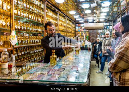 Junge jordanische Frauen, die Parfüms/Düfte in Einem Parfümgeschäft in Amman, Jordanien kaufen. Stockfoto