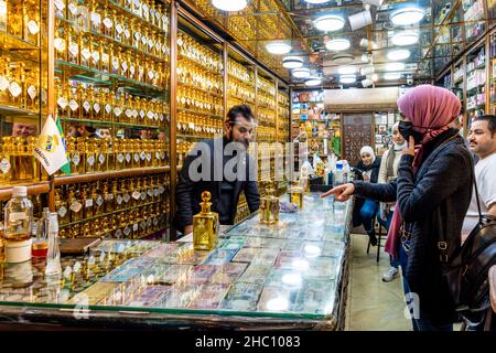 Junge jordanische Frauen, die Parfüms/Düfte in Einem Parfümgeschäft in Amman, Jordanien kaufen. Stockfoto