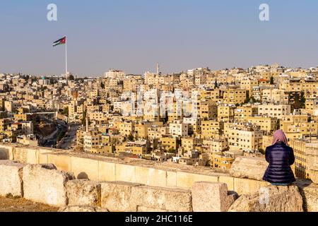 Eine junge Frau blickt von der Zitadelle, Amman, Jordanien, über die Skyline von Amman. Stockfoto