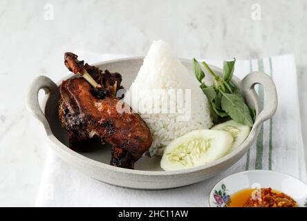 Bebek ireng Madura oder Black Duck typisches Street Food in Surabaya, Ost-Java, Indonesien. Serviert mit Cone Shape Warm White Reis und Sambal Stockfoto