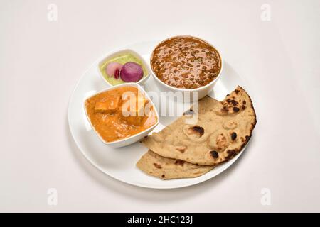 Paneer Butter Masala und Daal Makhani servierten mit Tandoori Roti in Platte isoliert auf weißem Hintergrund Stockfoto