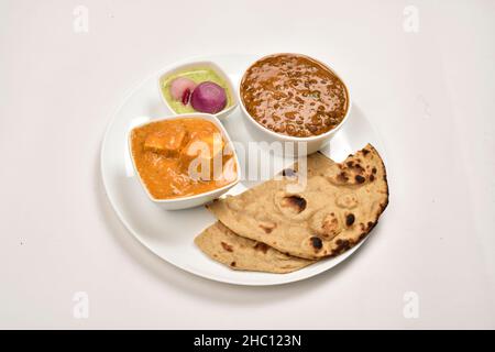 Shahi Paneer und Dal Makhani serviert mit Tandoori Roti und Chutney eingelegten Zwiebeln auf dem Teller Stockfoto
