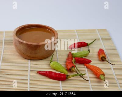 Erdnusssauce in einer kleinen Holzschüssel isoliert auf weißem Hintergrund. Stockfoto